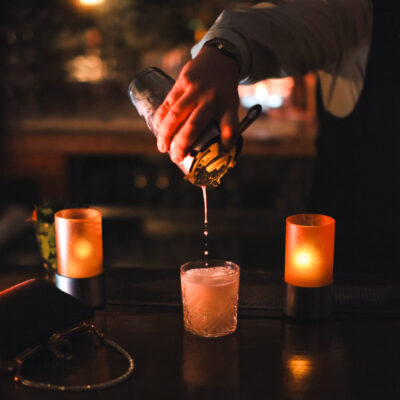 Smooth cocktail pour amidst cozy inviting bar ambiance e1763641089596